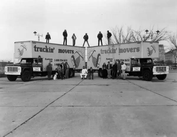 Doug Carlton standing between Truckin' Movers trucks in the early days