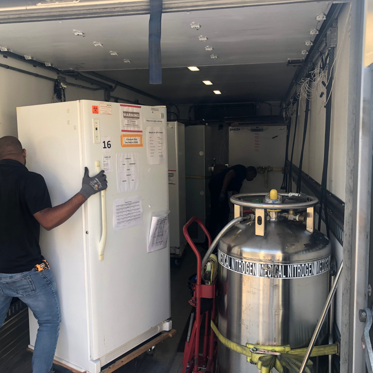 Mover putting a fridge inside a loading truck