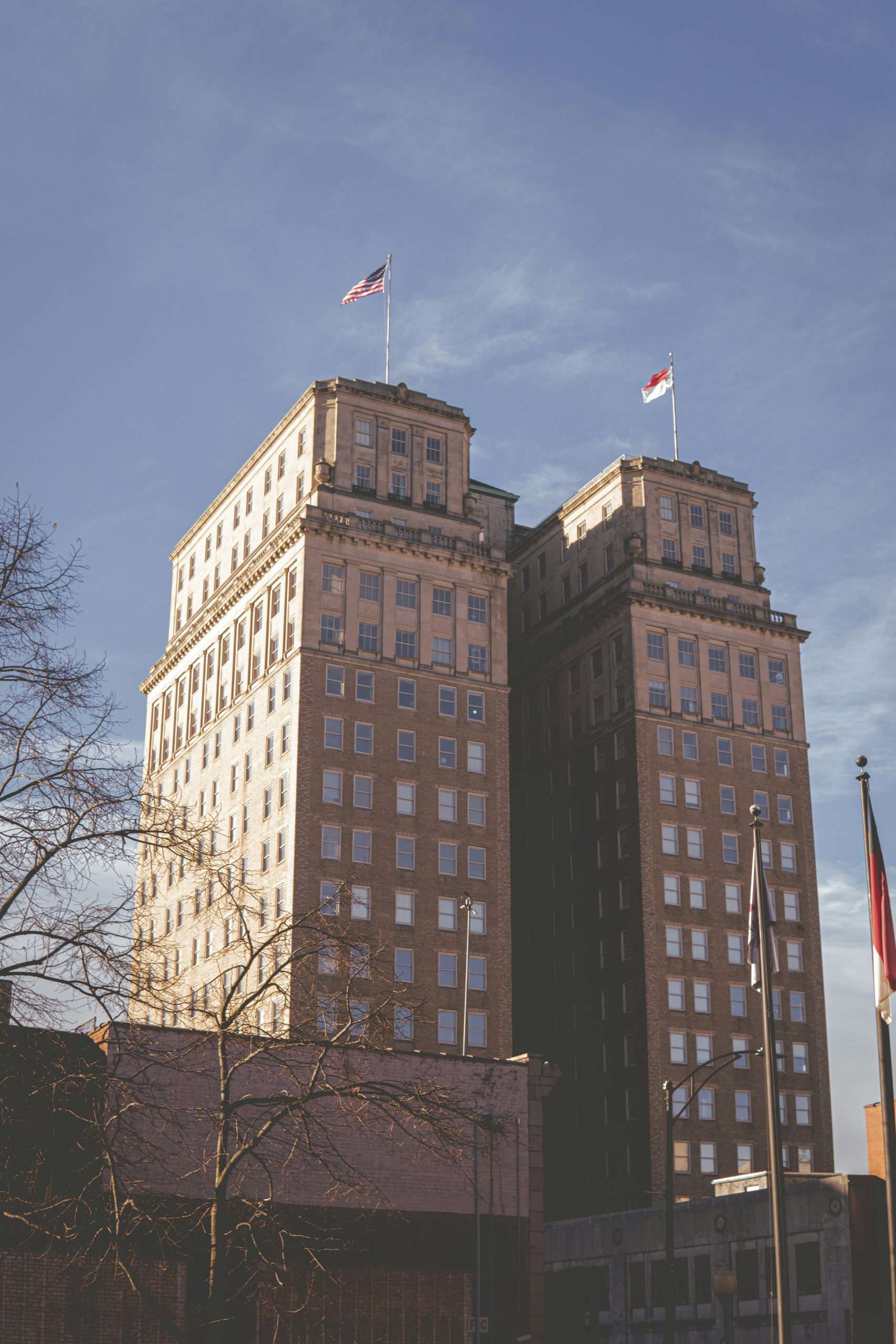 dominic-chasse-XP9XseF-sqw-unsplash Tall brick building with flags on top.